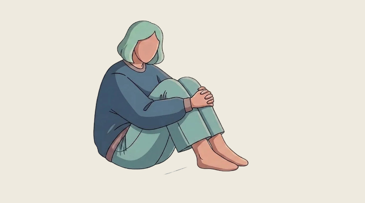 A minimalist vector illustration of a person sitting on the floor with their knees drawn up, wearing a dark blue long-sleeve top and light teal pants, set against a solid cream background.